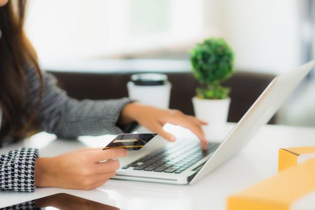 Retrato bela jovem mulher asiática usar cartão de crédito com o laptop para compras on-line