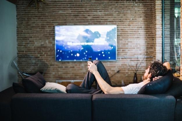 Homem relaxante no sofá em casa